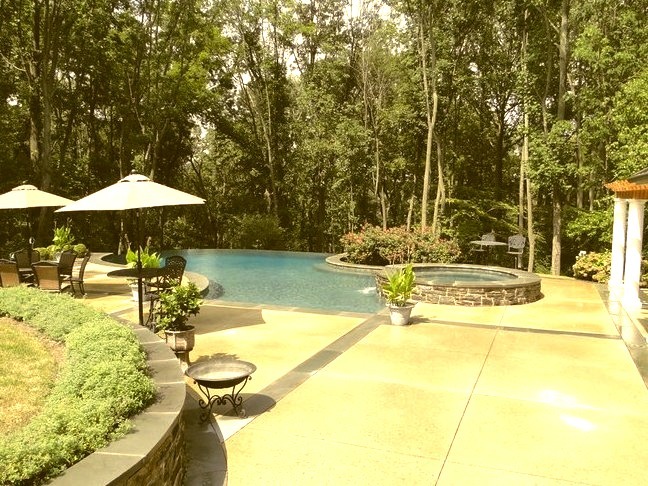 Large contemporary backyard fountain with an infinity pool and custom shape